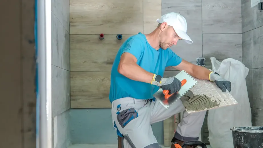 Home services professional installing tile.
