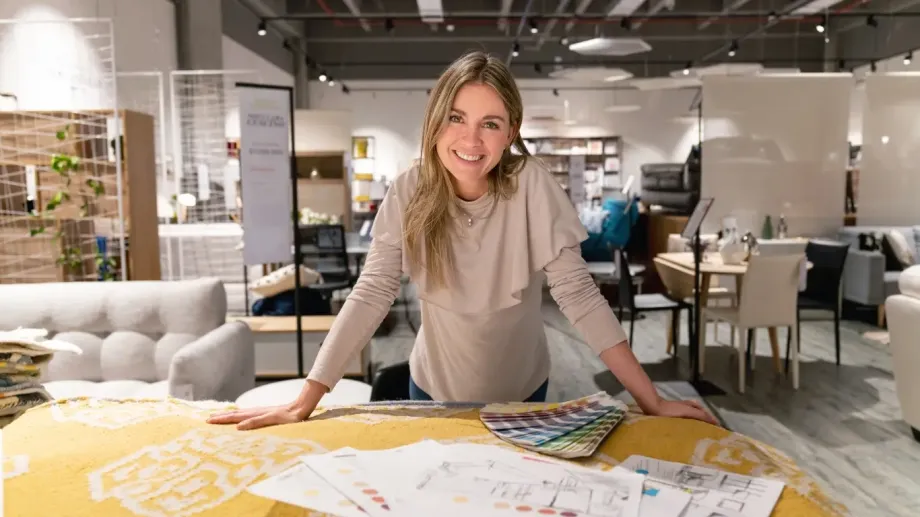 Small business owner smiling and looking at the camera from behind business tools.